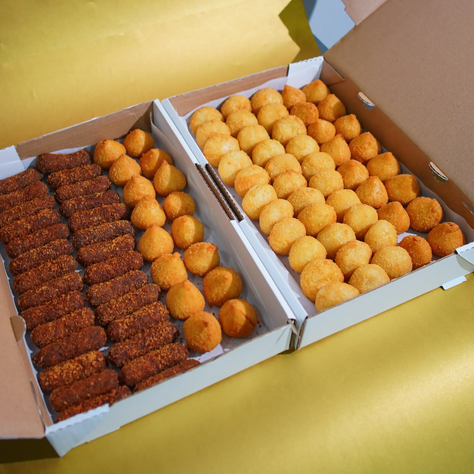 Caixa de cento com mini salgados fritos: kibes, bolinhas e coxinhas