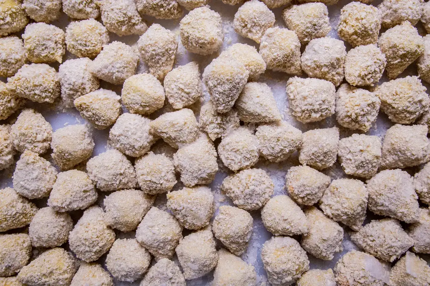 Mini salgados empanados crus, prontos para congelar