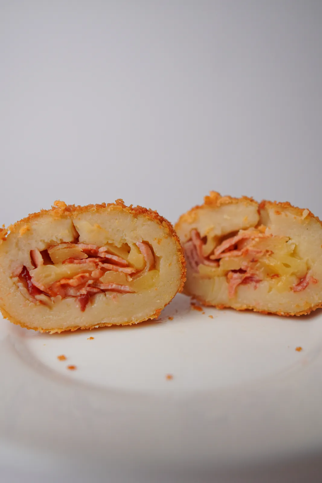 Salgado de provolone com bacon aberto ao meio, num prato branco